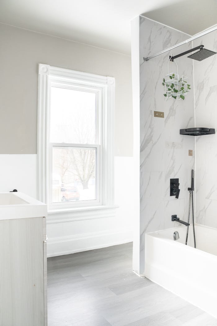 Bright minimalist bathroom featuring a marble shower and sleek fixtures.