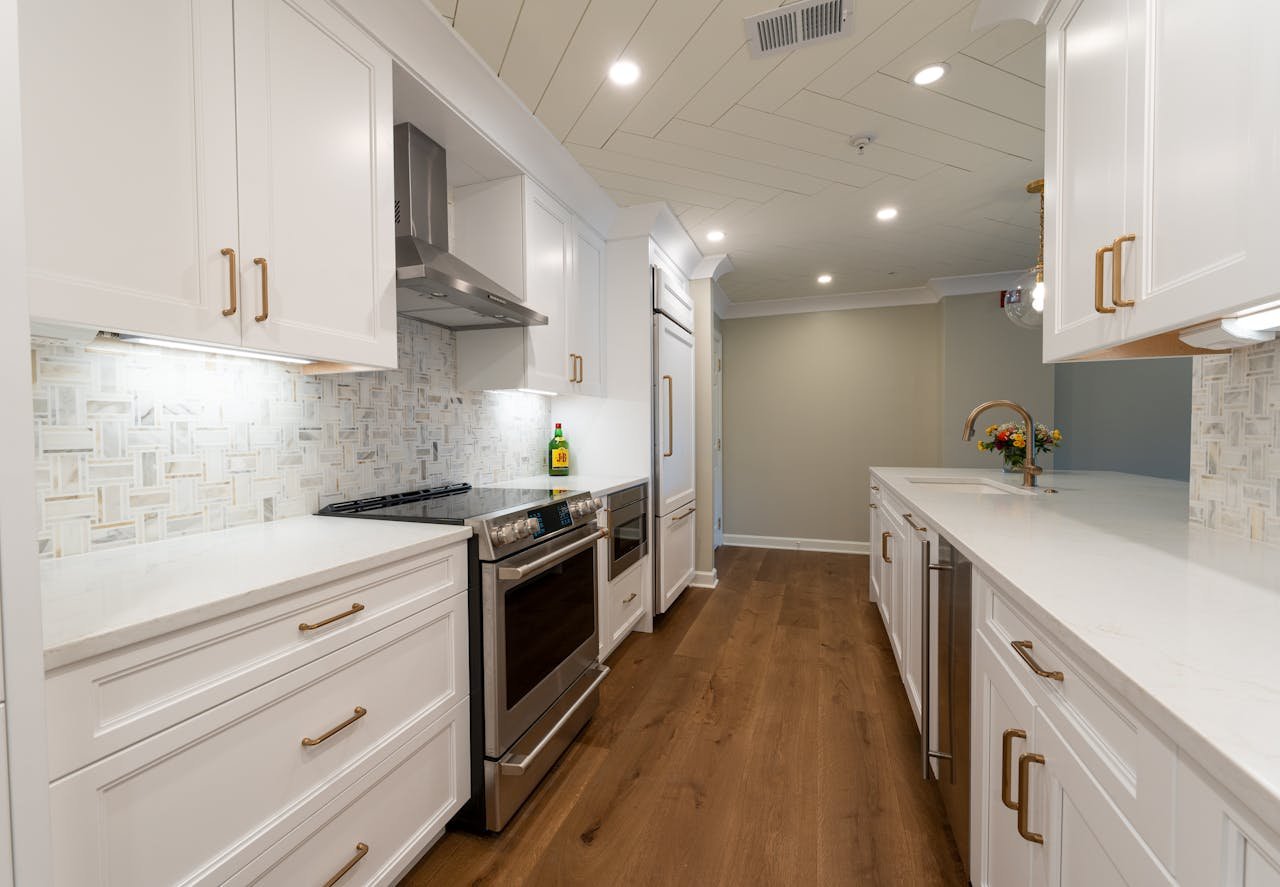 Sleek contemporary kitchen design featuring white cabinetry and stainless steel appliances.